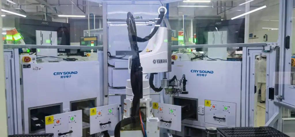 Automated headphone audio test cell with robotic handling and acoustic test chambers