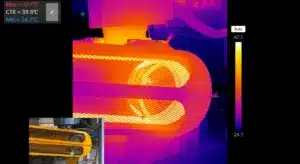 L’inspection par imagerie thermique montre la répartition de la chaleur sur une transmission par courroie industrielle et un carter de protection.